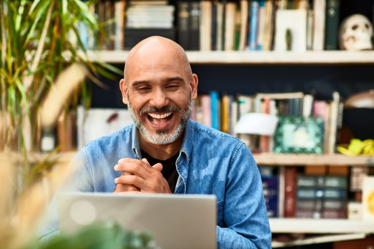 Empreendedor sorridente usando um laptop para formalizar seu negócio como MEI